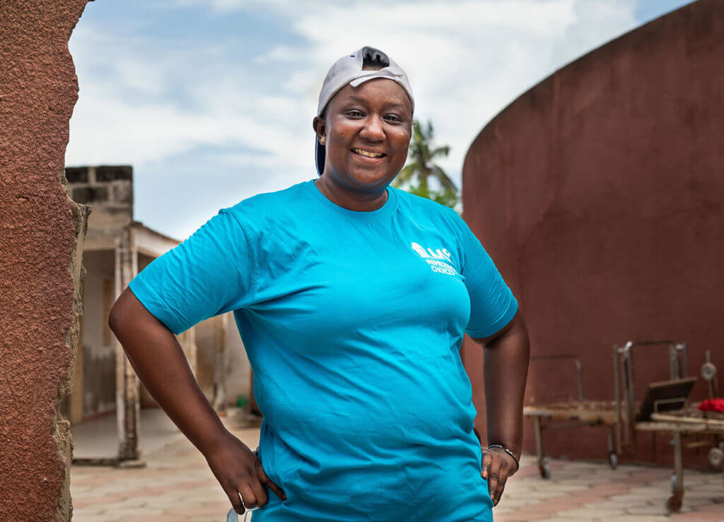 Fambaye, a woman in an MSI t-shirt and backwards baseball cap, stands in an remote village in Senegal. The anti-choice movement creates barriers to bringing choice to these communities.