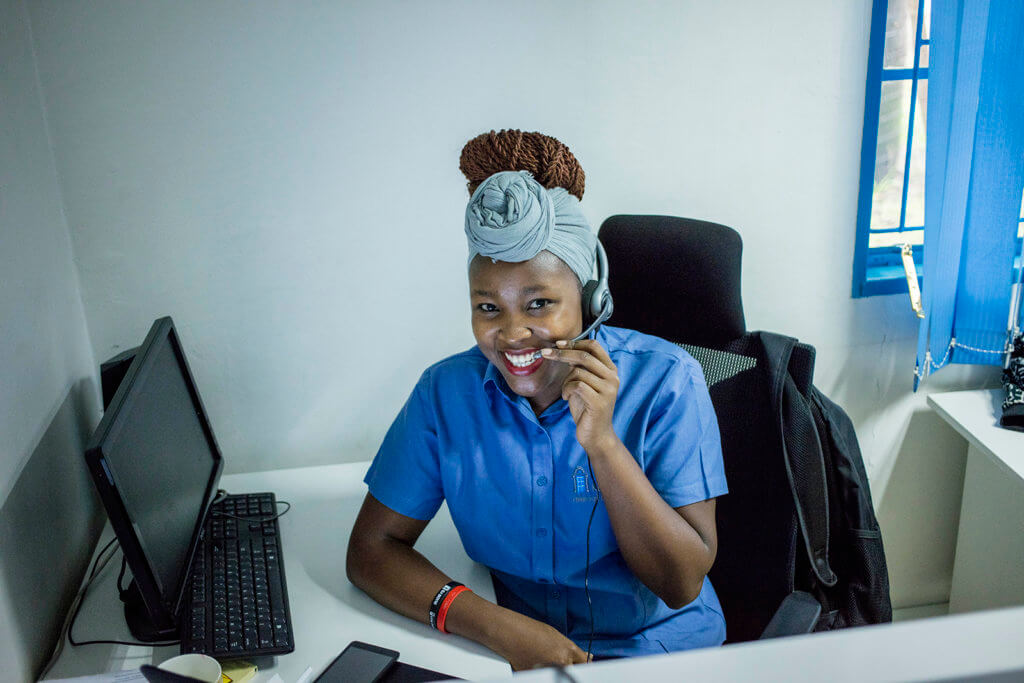 A smiling young woman works at a contact center, supporting MSI clients.