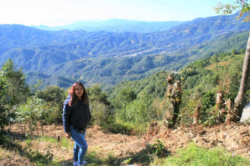 Yadira, an MSI team member in Oaxaca, stands in front of a mountain view.
