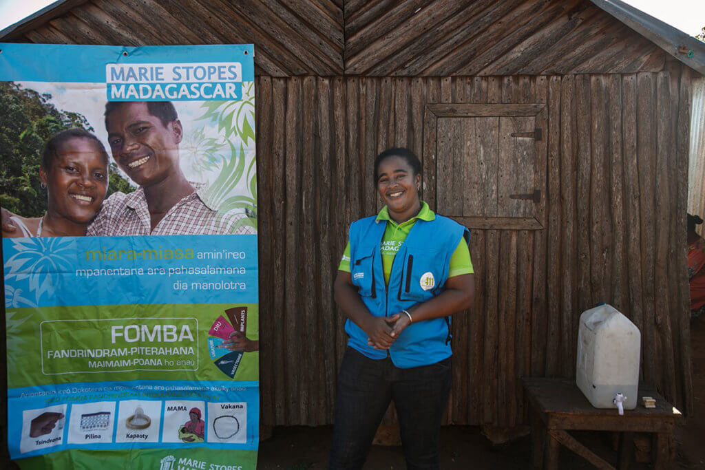 Jeannica stands in front of an outreach site, where she provides contraception in Madagascar.